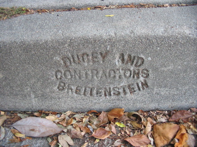 'Ducey and Breitenstein, Contractors' on the side of a sidewalk.