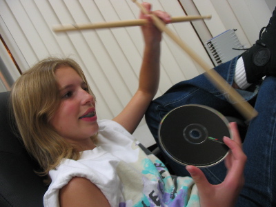 posing with her drum sticks and an interpol cd