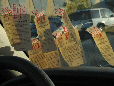 Several old parking passes on a windshield.