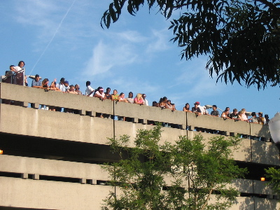 People on top of the parking structure, watching the scene.