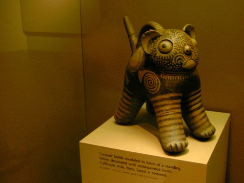 it says 'do not want' and is labeled 'ceramic bottle modeled in form of a standing feline, decorated with resist-painted motif, gallinaro style, peru'