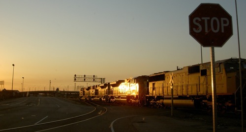 a train and a stop sign as the sun set